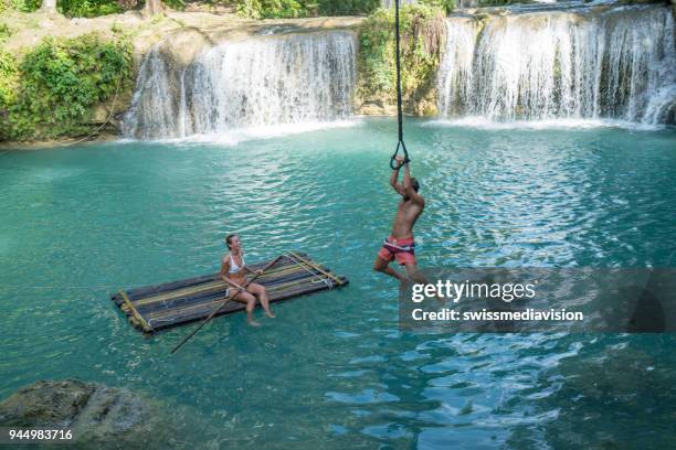 young couple playing at beautiful waterfall in the philippines - waterfall jump stock pictures, royalty-free photos & images
