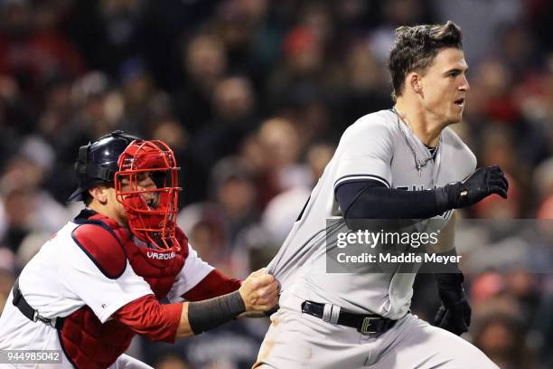Christian Vazquez of the Boston Red Sox tries to hold back Tyler Austin of the New York Yankees as he storms the pitchers mound after being stuck by...