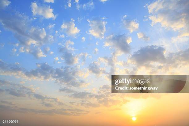 il sole splende attraverso bassa cloud - sunset sky foto e immagini stock