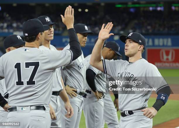 Brandon Drury of the New York Yankees is welcomed by manager Aaron Boone and teammates during pre-game introductions on Opening Day before the start...