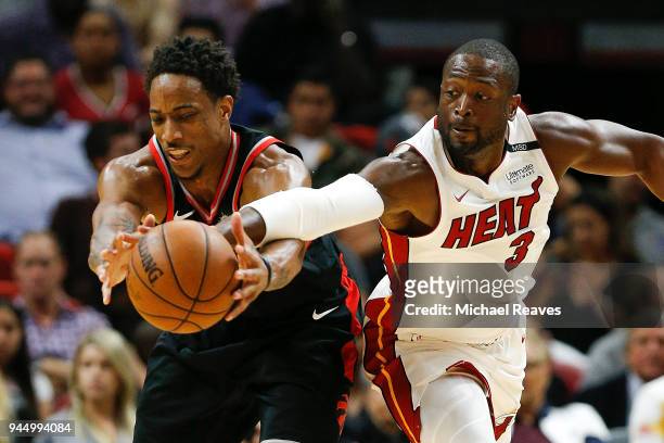 Dwyane Wade of the Miami Heat attempts to steal the ball from DeMar DeRozan of the Toronto Raptors during the second half at American Airlines Arena...