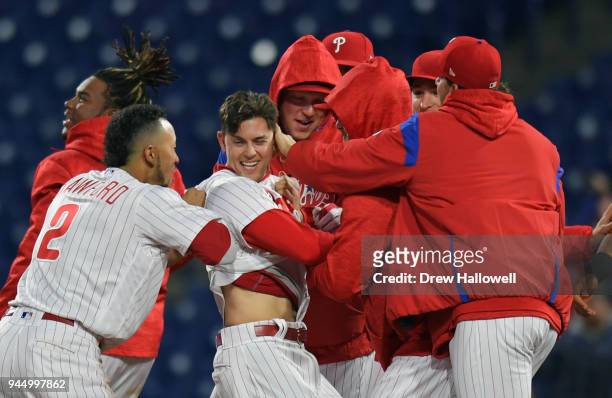 Scott Kingery of the Philadelphia Phillies gets congratulated by J.P. Crawford and other teammates after a walk off sacrifice fly in the twelfth...