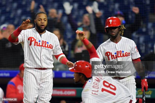 Carlos Santana and Odubel Herrera of the Philadelphia Phillies go to celebrate the game winning run by teammate Pedro Florimon in the twelfth inning...