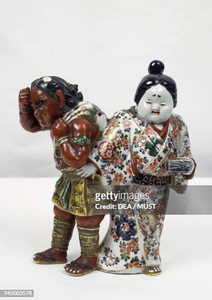 Fujin god of the wind accompanied by a woman, polychrome ceramic, height 27 cm. Japan, 19th-20th century.