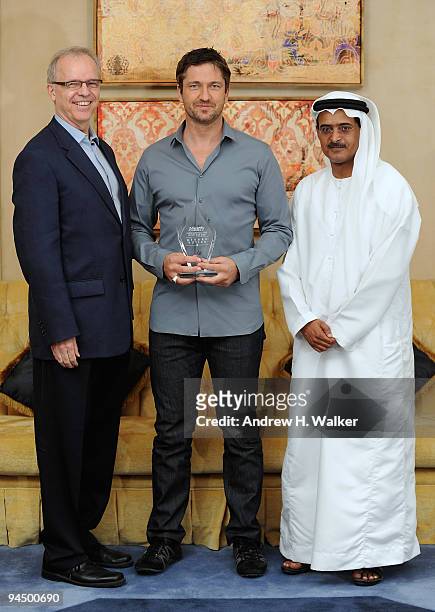 Timothy H Grey, editor of Variety magazine, actor Gerard Butler with his Variety International Star of the Year Award and DIFF Chairman Abdulhamid...