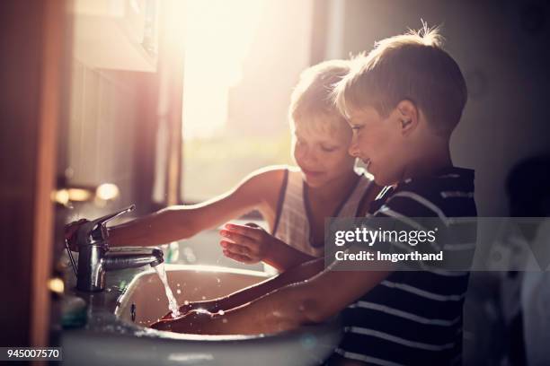 kleine jungen, die hände zu waschen - brothers bathroom stock-fotos und bilder