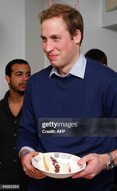 Britain's Prince William holds a bowl of birthday cake during a visit to the charity Centrepoint, on their 40th anniversary, at one of their centres...