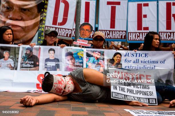 Protester lies on the ground acting out a victim of an extrajudicial killing during a protest by Filipino migrant organisations, as well as local and...