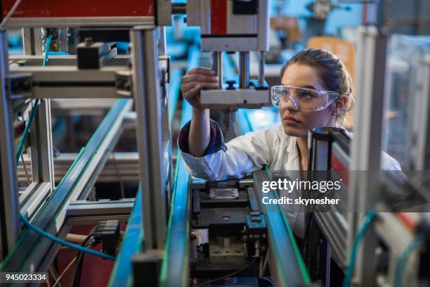 quality control worker analyzing machine part in laboratory. - manufatura imagens e fotografias de stock