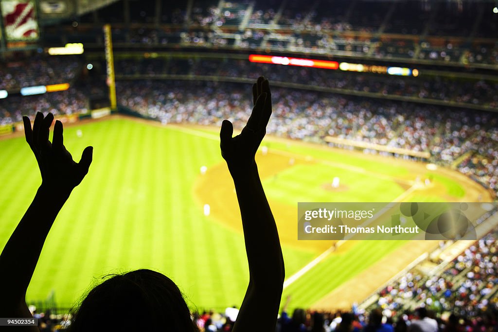 Silhouette of Baseball fan waving hands in the air