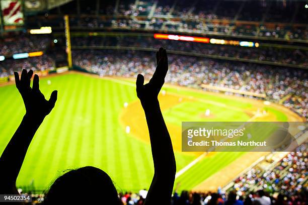 silhouette of baseball fan waving hands in the air - baseball stock pictures, royalty-free photos & images