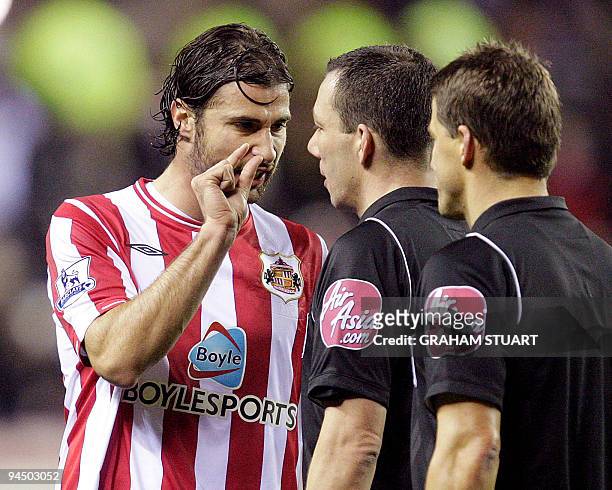 Sunderland's Lorik Cana talks with the referee, Kevin Friend at half-time against Aston Villa during an English FA Premier League, football match, at...