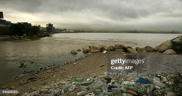 Smog covers the skyline of Beirut while empty plastic bottles and trash pollute the shore of the Mediterranean off Dbayeh, as suburb of the Lebanese...