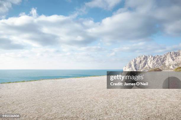 flat gravel plateau next to ocean with background rocks - gravidas imagens e fotografias de stock