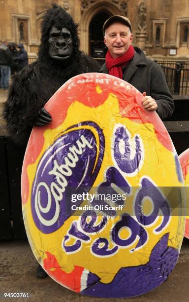 Man dressed as a gorilla and singer Billy Bragg pose with a poster of a giant Cadbury Creme Egg as they protest against the potential sale of Cadbury...