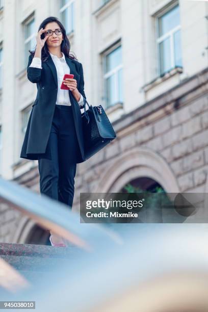mooie zakenvrouw met telefoon in de hand - 2017 common good forum stockfoto's en -beelden