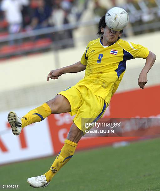 Thailand's Kirati Keawsombut heads a ball against Malaysia in their men's football match at the 25th Southeast Asian Games in Vientiane on December...