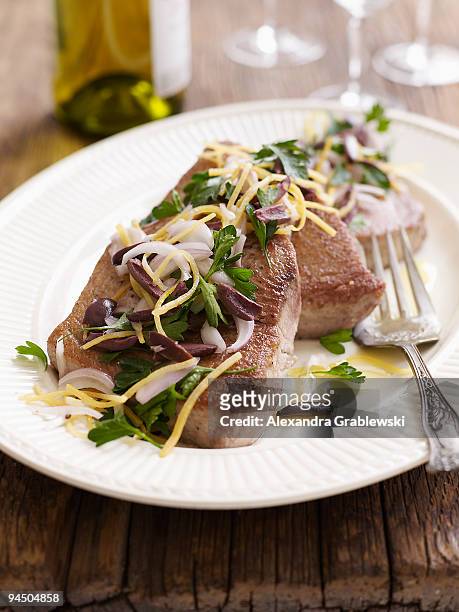 platter of albacore tuna steaks with olive salsa - albacore tuna stock-fotos und bilder