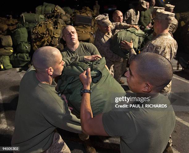 Marines from Camp Lejeune, North Carolina, forma chain to load equipment into trucks late December 15 as they prepare to deploy to Afghanistan....