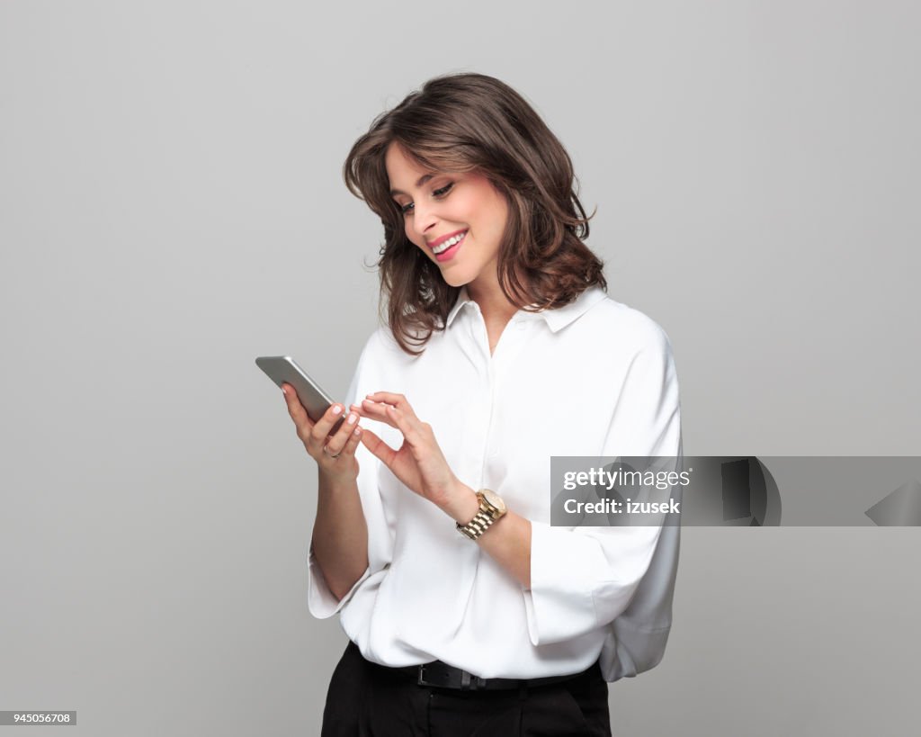 Beautiful young businesswoman using smart phone
