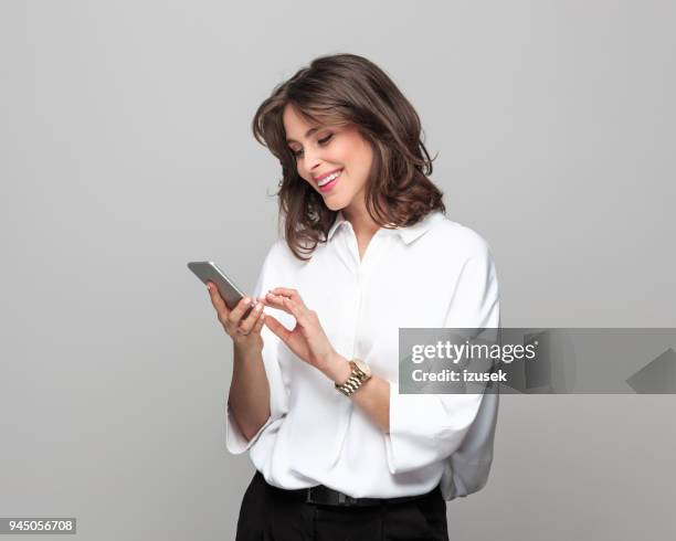 bela jovem empresária usando telefone inteligente - camisa branca - fotografias e filmes do acervo