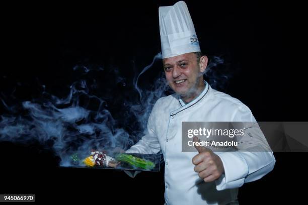 Orhan Eryilmaz, Executive Chef at Susesi Luxury Resort holds a smoking food plate as he poses for a photo in Antalya, Turkey on April 11, 2018. Taste...
