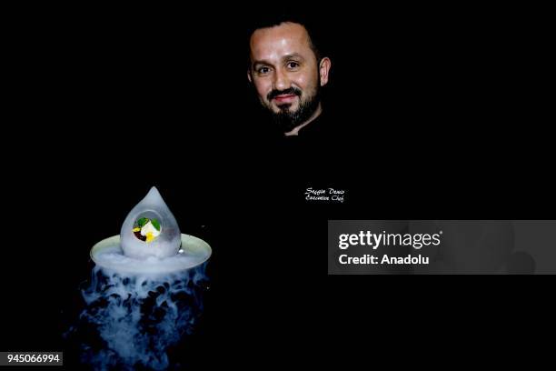Secgin Demir, Executive Chef at Kaya Palazzo Golf Resort holds a smoking food plate as he poses for a photo in Antalya, Turkey on April 11, 2018....