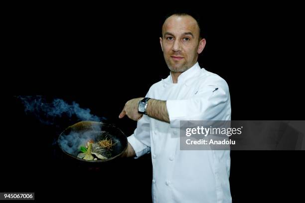 Levent Biyik, Executive Sous Chef at Tha Land of Legends Hotel holds a smoking food plate as he poses for a photo in Antalya, Turkey on April 11,...