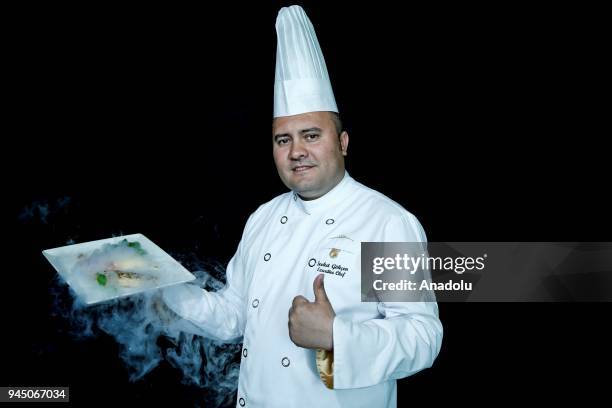Sevket Gokcen, Executive Chef at Regnum Carya Golf ve Spa Resort holds a smoking food plate as he poses for a photo in Antalya, Turkey on April 11,...