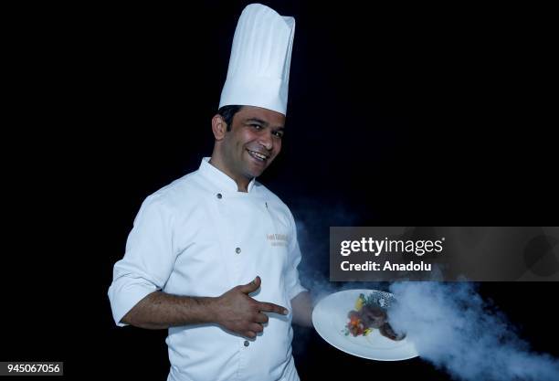 Cemil Karaburcak, Executive Chef at Robinson Club Nobilis holds a smoking food plate as he poses for a photo in Antalya, Turkey on April 11, 2018....