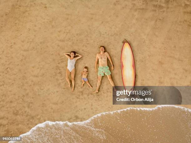 luchtfoto van de familie op het strand - liggen stockfoto's en -beelden