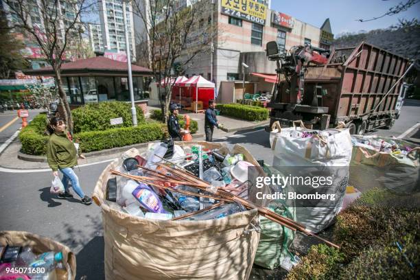 Bags of uncollected plastic waste sit by a street as waste collectors prepare to pick them up in Yongin, South Korea, on Wednesday, April 11, 2018....