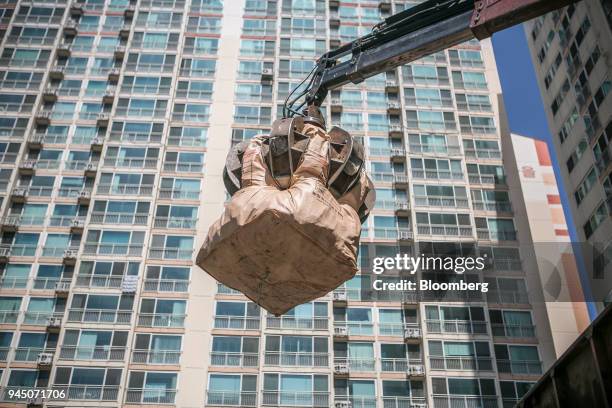 Crane claw picks up a bag of plastic waste in front of an apartment building in Yongin, South Korea, on Wednesday, April 11, 2018. Some South Korean...
