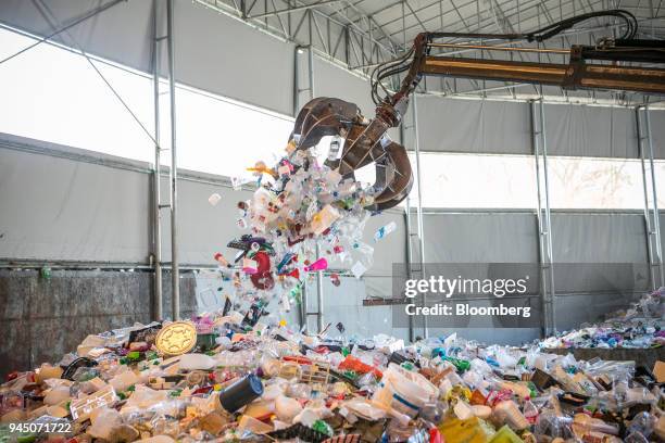 Crane claw unloads plastic waste onto a stockpile at a recycling center in Yongin, South Korea, on Wednesday, April 11, 2018. Some South Korean...