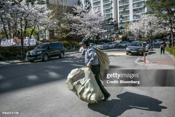 Security guard at an apartment complex carries bags of plastic waste in Yongin, South Korea, on Wednesday, April 11, 2018. Some South Korean...
