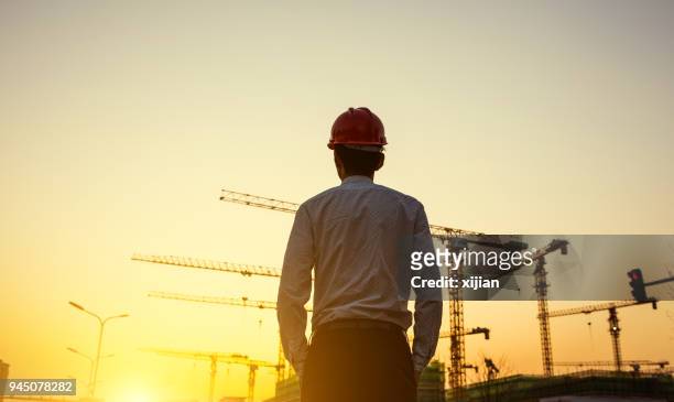 ingegnere con sfondo gru al tramonto - torre struttura edile foto e immagini stock