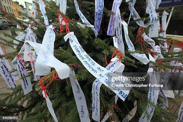 Wishing tree festooned with messages of good will stands in Cockermouth Market Place on December 16, 2009 in Cockermouth, England.. An army of...