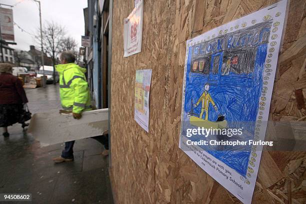 Drawing of a helicopter rescue by a pupil of Cockermouth Primary Schools adorns a flood damaged shop on the High Street on December 16, 2009 in...