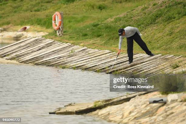 Rafa Cabrera-Bello of Spain retrieves his ball from the water on the 17th hole during day one of Open de Espana at Centro Nacional de Golf on April...