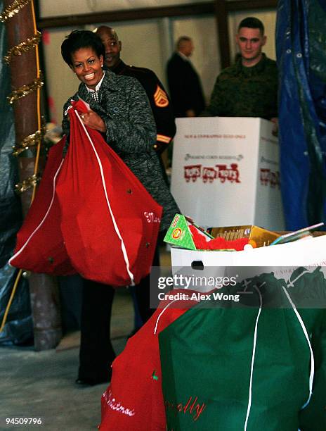 First lady Michelle Obama carries a bag of toys as she delivers donations collected by White House Executive Office staff to the Marine Toys for Tots...