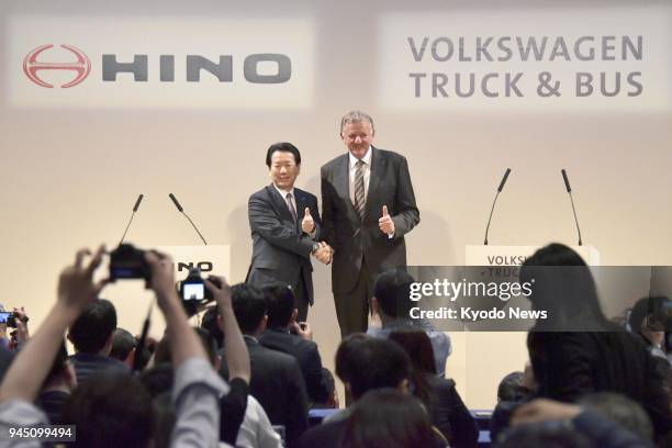 Hino Motors Ltd. President Yoshio Shimo and Volkswagen Truck &amp; Bus GmbH CEO Andreas Renschler shake hands during a press conference in Tokyo on...