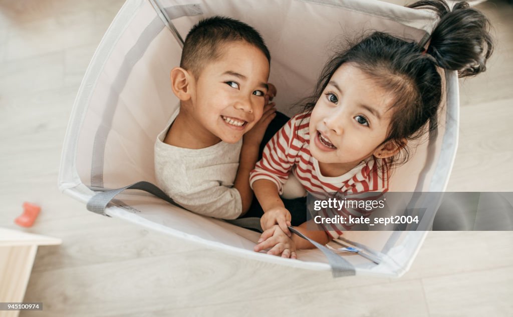 Siblings Hiding Inside the Laundry Bin