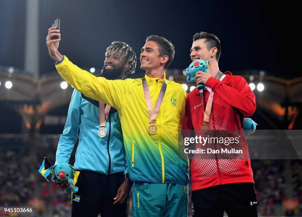 Silver medalist Jamal Wilson of the Bahamas, gold medalist Brandon Starc of Australia and bronze medallist Django Lovett of Canada pose for a selfie...