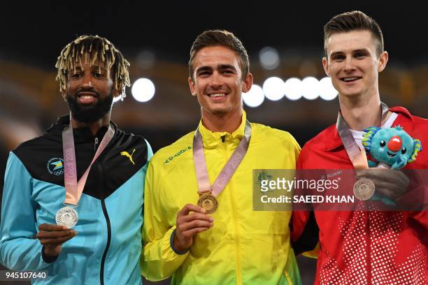 Australia's Brandon Starc , Bahamas' Jamal Wilson and Canada's Django Lovett pose with thier medal a day after the athletics men's hig jum during the...