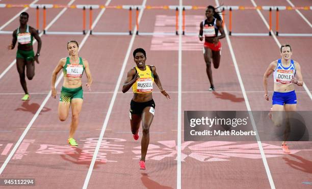 Janieve Russell of Jamaica races to the line to win gold ahead of Wenda Nel of South Africa and Eilidh Doyle of Scotland in the Women's 400 metres...