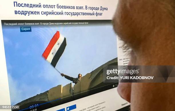 This photograph taken on April 12 shows a man as he looks at a computer screen in Moscow, displaying a web page in Russian cyrillic script with a man...