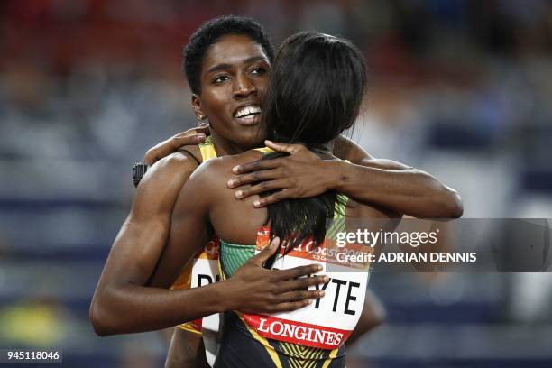 Jamaicas Janieve Russell celebrates with Jamaicas Ronda Whyte after winning the athletics women's 400m hurdles final during the 2018 Gold Coast...