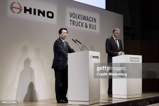 Yoshio Shimo, president and chief executive officer of Hino Motors Ltd., left, speaks while Andreas Renschler, chief executive officer of Volkswagen...