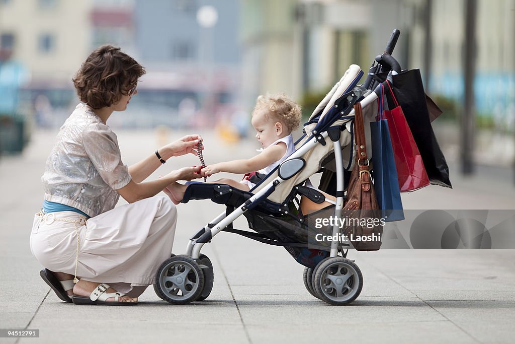 Baby in a stroller while her mother gives her a gift