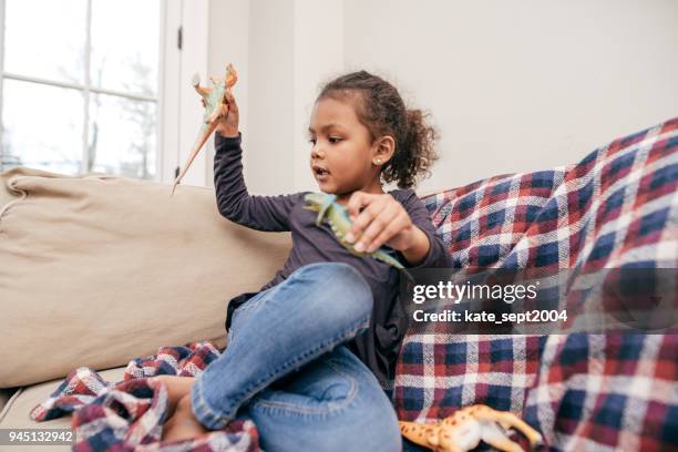 a girl playing with dinosaurs - dinosaur toy i stock pictures, royalty-free photos & images